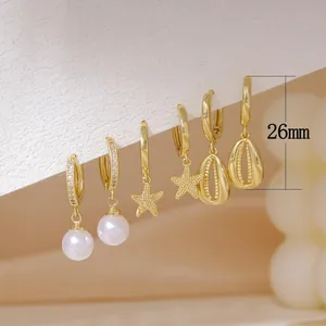 Detailed view of three gold earring styles featuring pearls, stars and shell charms