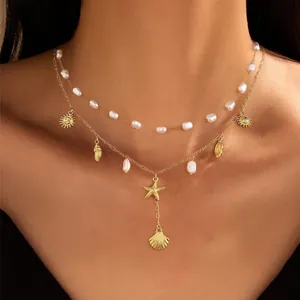 Double-layered gold-plated necklace with irregular pearls and ocean shell charms on model