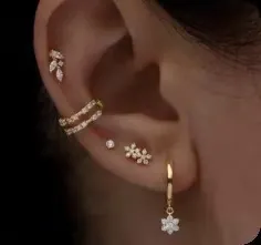 Detail of five-piece gold plated brass earring set with white zircon flower designs