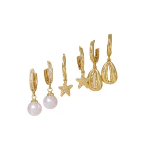 Golden 6-piece earring set featuring white pearl, star, and shell charms on white backdrop