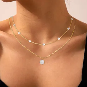 Detail of elegant gold double-layer necklace with multiple pearls and round pendant