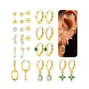 Detail of gold plated earring set featuring stud hoops and green drop pendant charms