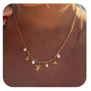 Golden ocean charm necklace featuring starfish shells and pearls on a dainty chain