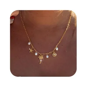 Detailed shot of golden beach necklace featuring starfish, shell and pearl pendants