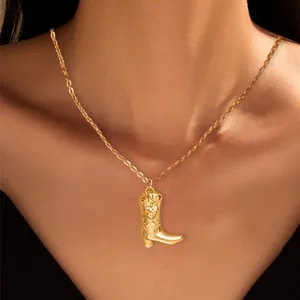 Gold-plated brass necklace featuring a vintage cowboy boot pendant with textured embossing