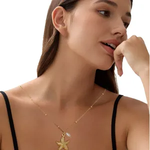 Gold starfish and pearl necklace on model, elegant layered bead chain for summer