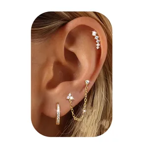 Three-piece gold plated brass earring set with zircon hoops and chain stud on ear