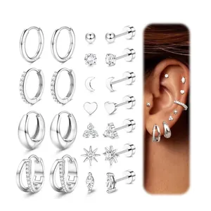 Macro detail of silver earring set featuring hoop designs and crystal studs on a white background