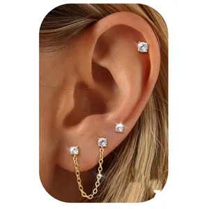 Detailed view of three gold-plated stud earrings and a double-piercing chain earring set