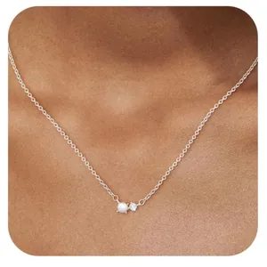 Elegante goudvergulde messing ketting met een fijne parel en zirkoon hanger op een model