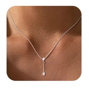 Detailopname van minimalistische messing vergulde ketting met zirkoon hanger op model