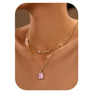 Close-up of double-layered gold necklace with pink emerald-cut and purple zircon stones