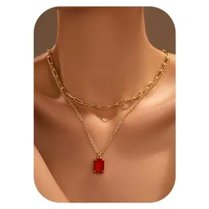 Close-up of double layer gold necklace featuring a red square zircon pendant on model