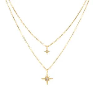 Close-up of gold plated layered necklace with sparkling zircon North Star pendants
