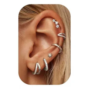 Nahaufnahme eines silbernen Messing-Ohrring-Sets mit Zirkonia am Ohr des Models