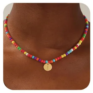 Détail du collier de perles colorées avec pendentif rond doré gravé de la lettre I