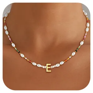Detail of bohemian pearl necklace featuring colorful beads and a golden letter E pendant