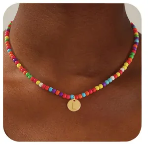 Gros plan d'un collier de perles colorées avec un pendentif lettre L dorée sur un mannequin