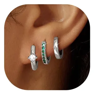 Close-up of silver-plated hoop earrings set with emerald green and white zircon stones