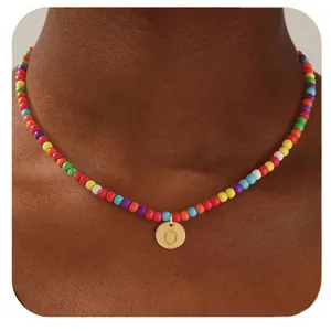 Gros plan d'un collier de perles colorées avec un pendentif cœur doré lettre O