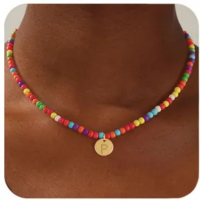 Vue rapprochée collier de perles colorées avec pendentif lettre P doré sur le cœur