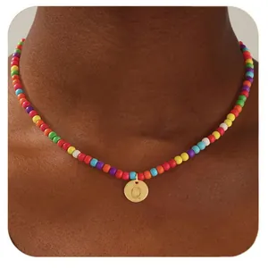 Détail d'un collier de perles colorées avec un pendentif lettre Q doré sur un mannequin