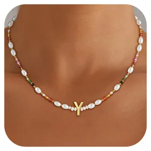 Detail of colorful beads and freshwater pearls necklace with golden letter Y pendant