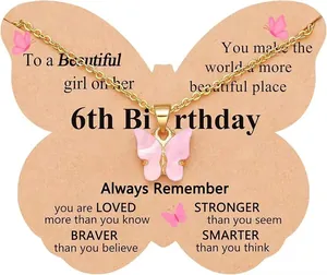 Detailed view of golden chain necklace with pink butterfly pendant on 6th birthday gift card