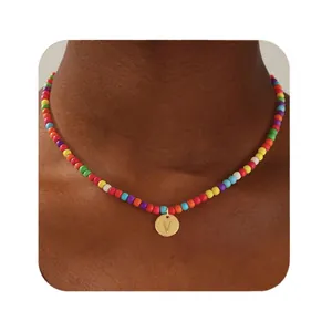 Collier en perles colorées avec pendentif rond doré arborant la lettre V gravée