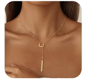 Détail macro d'un collier lasso doré en Y avec un anneau rond et un pendentif barre lisse