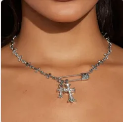 Detailopname van de verzilverde kruisketting met zirkonia hangers en speld ornament