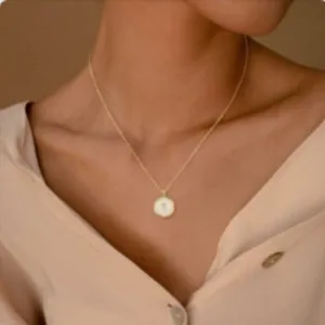 18K vergulde kruishanger ketting met witte schijf inleg op een model getoond