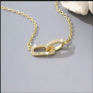 Elegante collar dorado de doble lazo con circonitas brillantes en micro pavé moderno
