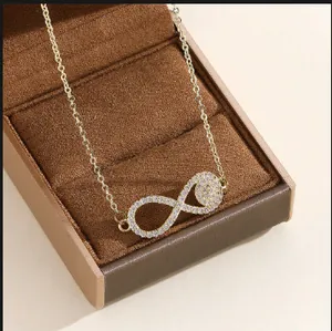 Collar de infinito dorado con circonitas presentado en una caja de regalo de lujo