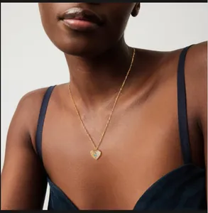 Détail du collier pendentif cœur avec pierre bleue sur une chaîne dorée