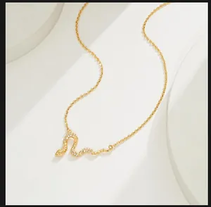 Gros plan détaillé du pendentif serpent doré serti de zircons brillants sur la chaîne