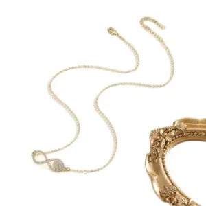 Collar dorado con símbolo de infinito y colgante circular con circonitas incrustadas