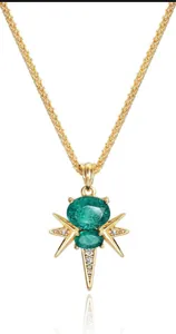 Détail de collier serpent plaqué or avec pierres précieuses vertes et motif étoile filante