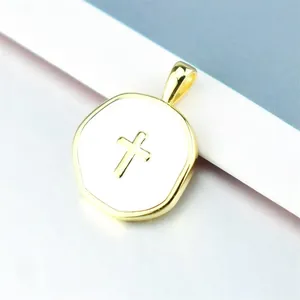 Macro shot of 14k gold-plated octagonal pendant with white enamel and cross detail
