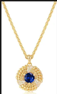 Gros plan d'un collier doré avec pierre bleue facettée et détails de sertissage en micro-pavé
