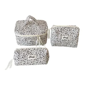 Three-piece quilted travel cosmetic bag set with black and white ink splash polka dots