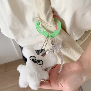 Cute white plush dog keychain with round glasses and green heart-shaped carabiner