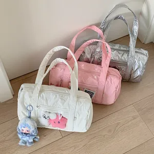 Three colors of quilted bow pattern barrel bags in white, pink and metallic silver