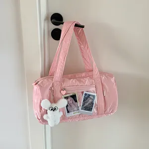 Detail of pink bow-embossed Boston bag with a transparent display pocket and plush charm