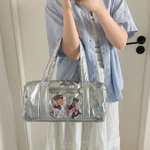 Detail of silver ita bag showing butterfly embossing and clear pocket with badges