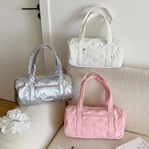 Close-up of quilted bow textures and heart zipper on colorful cylinder duffle bags