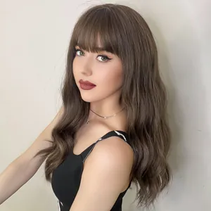 Long wavy synthetic wig with bangs in deep brown, shown on model against a grey background