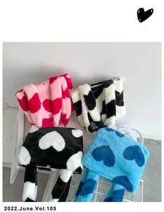 Gros plan de sacs cabas en peluche à motif cœur montrant la texture en fausse fourrure