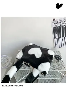 Gros plan d'un sac cabas en fausse fourrure à motif cœur noir et blanc sur étagère
