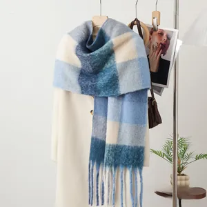 Detailed view of winter mohair scarf featuring blue and white plaid and long tassels